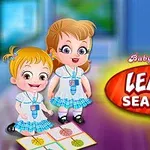 The image features two cartoon girls, Baby Hazel and her friend, in matching school outfits, engaging with a colorful mat featuring seasonal illustrations, with a bold title Baby Hazel Learn Seasons prominently displayed