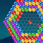 A colorful arrangement of shiny, multi-colored bubbles in a hexagonal pattern on a dark blue background, with a single red bubble in the center aimed at the cluster