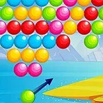 A colorful bubble shooter game displaying a variety of red, yellow, green, blue, and pink bubbles arranged in a triangular pattern above a shooter aiming at the bottom of the screen with a background featuring water and icy mountains