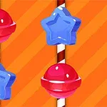 A bright orange background features red spherical candies and blue star-shaped candies arranged vertically on striped white and red sticks