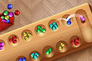 A wooden board with several holes containing colored balls, including green, blue, yellow, and red, alongside a red pouch spilling additional balls