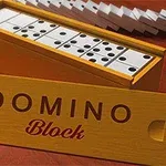 A wooden box containing a set of white dominoes with black dots, displayed beside a brightly colored label that reads DOMINO Block