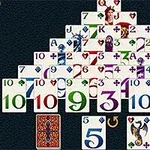 A colorful pyramid-shaped arrangement of playing cards featuring different suits and numbers, with a few face cards and a dragon and skull illustration, set against a dark background