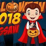 A cheerful cartoon boy in a vampire costume holds a pumpkin-shaped candy bucket, with Halloween 2018 Jigsaw text and a spooky background featuring silhouettes of trees and gravestones