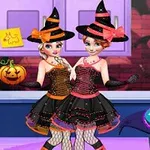 Two girls in witch costumes with colorful hats and dresses stand in a decorated room featuring a festive Halloween cake and Halloween-themed decorations