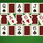 A tabletop display of playing cards featuring a sequence of cards including an Ace, two Sixes, and various others arranged on a green felt background, typical for games like poker