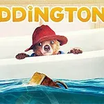 A cartoon bear wearing a red hat peeks over the edge of a bathtub filled with water, alongside a rubber duck and a floating cardboard box, with the title Paddington prominently displayed above