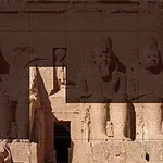 An ancient Egyptian temple facade featuring large stone statues and intricate carvings, highlighting the impressive architecture and artistry of the civilization