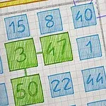 A hand-drawn grid of numbers on graph paper, featuring highlighted green squares for 3, 47, and 50, with various blue squares around them and a decorative star at the top