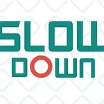 A graphic design featuring the phrase SLOW DOWN in bold, teal letters with a red circle, set against a light background and bordered by a zigzag pattern