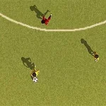 An aerial view of a soccer field showing three players, one in red and two in yellow, with a soccer ball on the grass