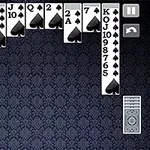 A digital solitaire game layout featuring cards from the suit of spades arranged in columns against a dark, patterned background, with a deck of face-down cards on the bottom right