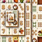 A colorful mahjong-style game board featuring various tiles with numbers, vegetables, seasonal decorations, and symbols like candles and pumpkins, set against a warm background