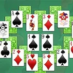 A colorful arrangement of playing cards featuring hearts and spades, including an Ace of spades, a Queen of hearts, and a Joker, set against a vibrant green background