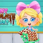 The image features a cheerful animated character with blonde hair and a pink bow, holding a tray of chocolate treats, against a backdrop with the text Yummy Chocolate Factory in colorful, playful lettering